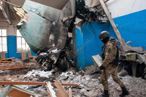 A Ukrainian serviceman walks past the remains of a Russian aircraft lying in a damaged building in Kharkiv on March 8.
