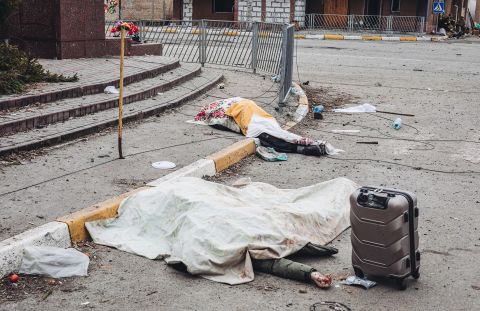 The dead bodies of civilians killed while trying to flee are covered by sheets in Irpin on March 6. CNN determined they were killed in <a href=