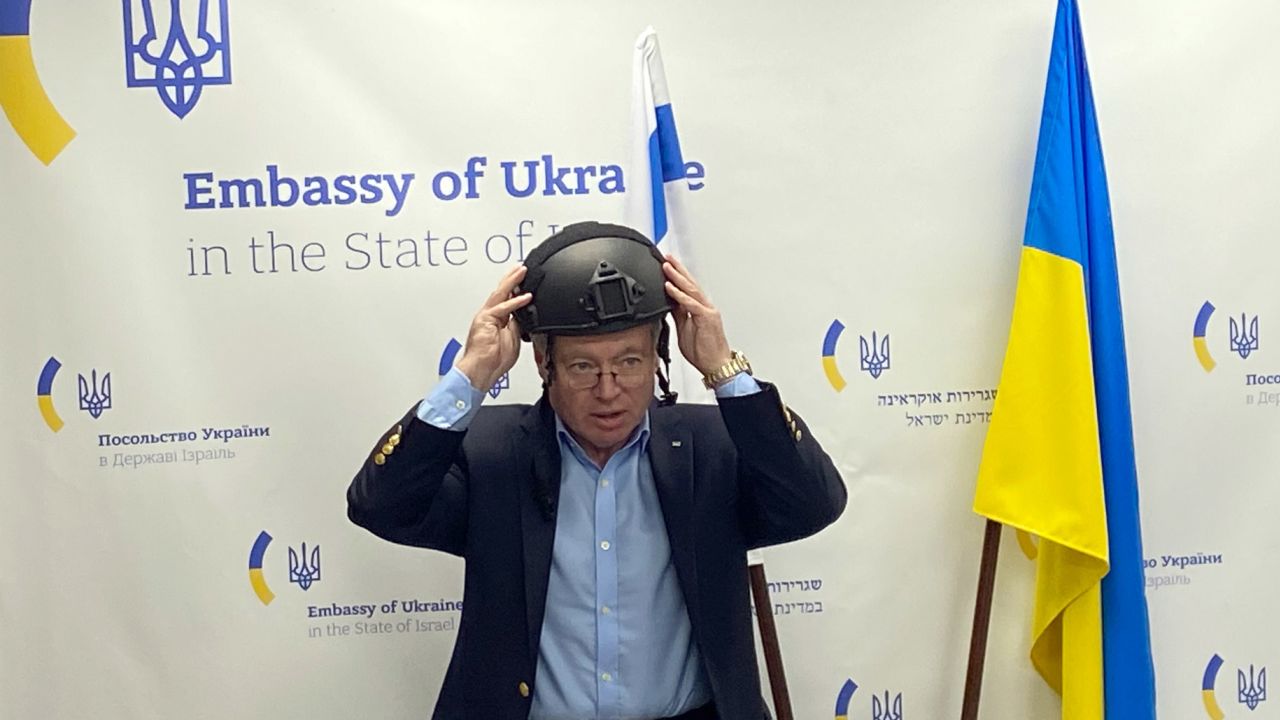 Yevgen Korniychuk, Ukraine's ambassador to Israel, puts on a protective helmet at a press conference on March 7. 