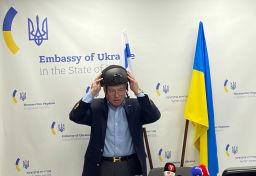 Yevgen Korniychuk, Ukraine's ambassador to Israel, puts on a protective helmet at a press conference on March 7. 