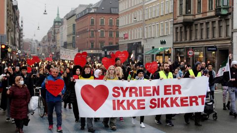 Demonstrators march with a banner reading "Syria is not safe" during a protest against the government's policy of returning some Syrian refugees in Copenhagen on November 13, 2021.