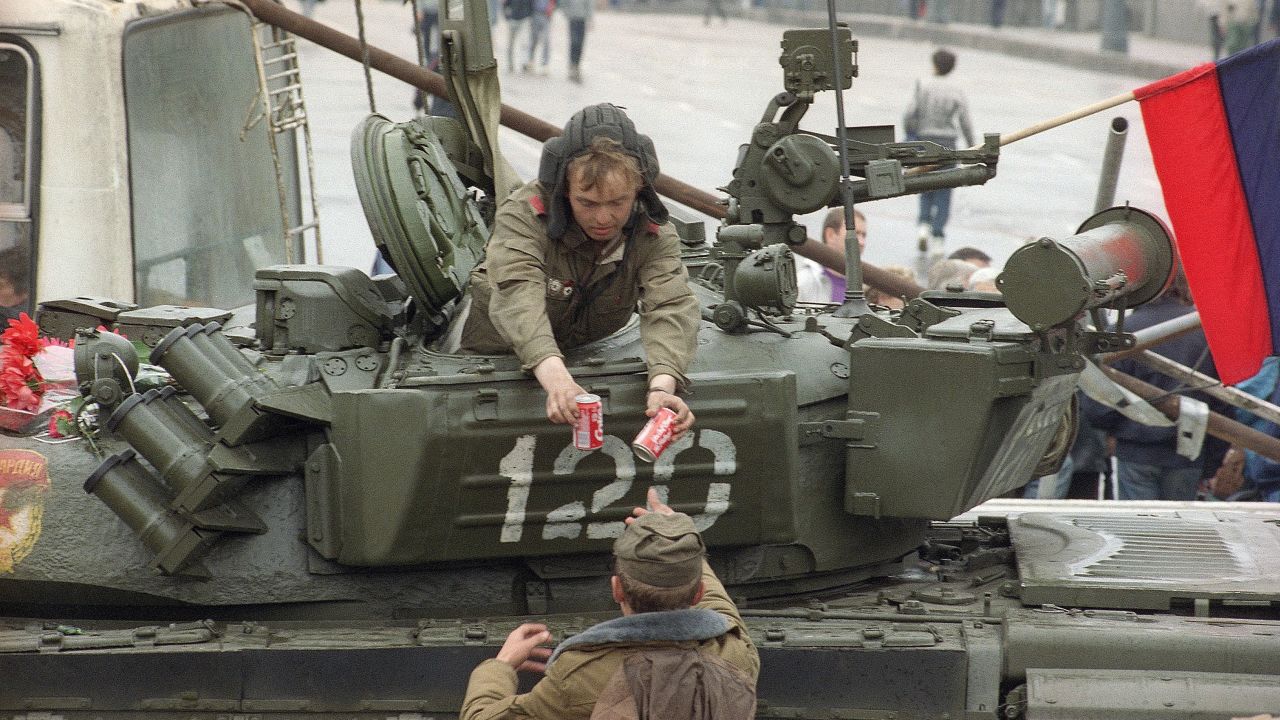 A soldier gives two cans of Coca-Cola to a tank driver near the Russian Federation building in Moscow, August 21, 1991.