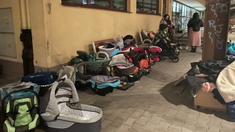 Car seats and carriers line the wall of the Przemyśl train station.
