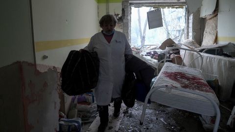 A medical worker walks inside the damaged hospital.
