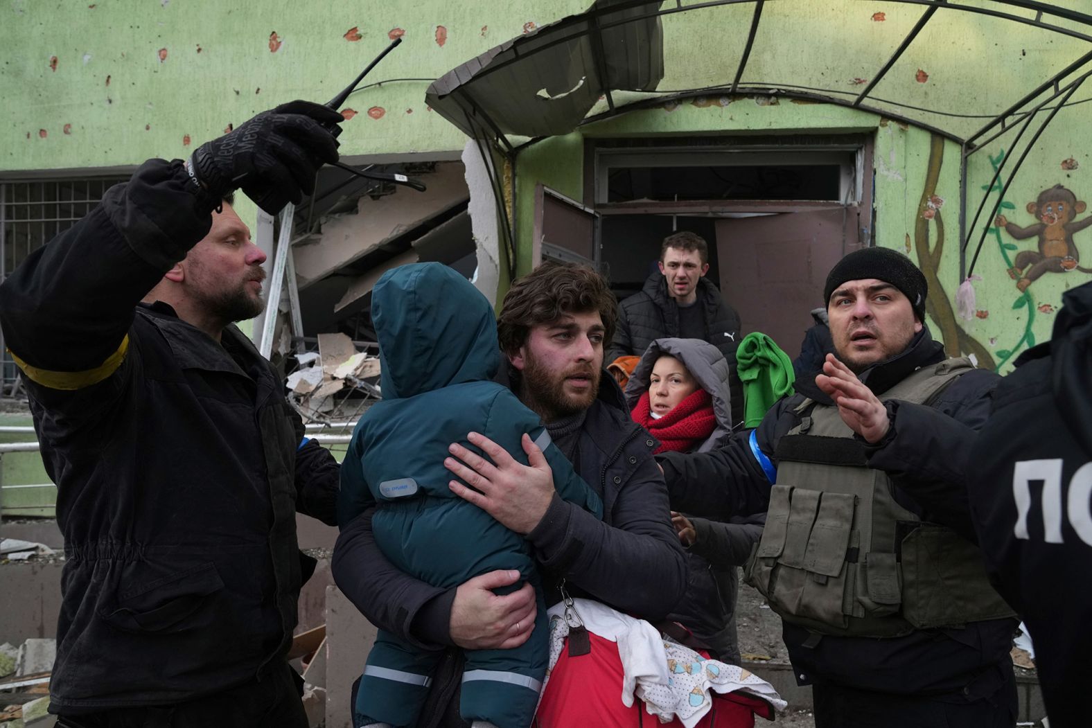 A man carries his child away from the hospital.