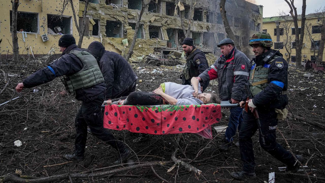 Ukrainian emergency workers carry an injured pregnant woman from the damaged maternity hospital in Mariupol, Ukraine, on Wednesday.