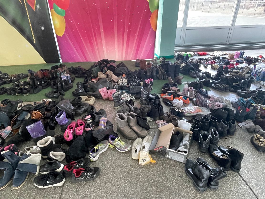 Donated shoes, clothes and children's toys are piled up ready for distribution when the refugee convoys arrive from Mariupol.