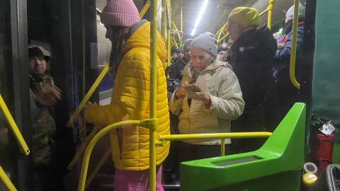 Refugees from Enerhordar alight the evacuation bus after document checks by Ukrainian soldiers.