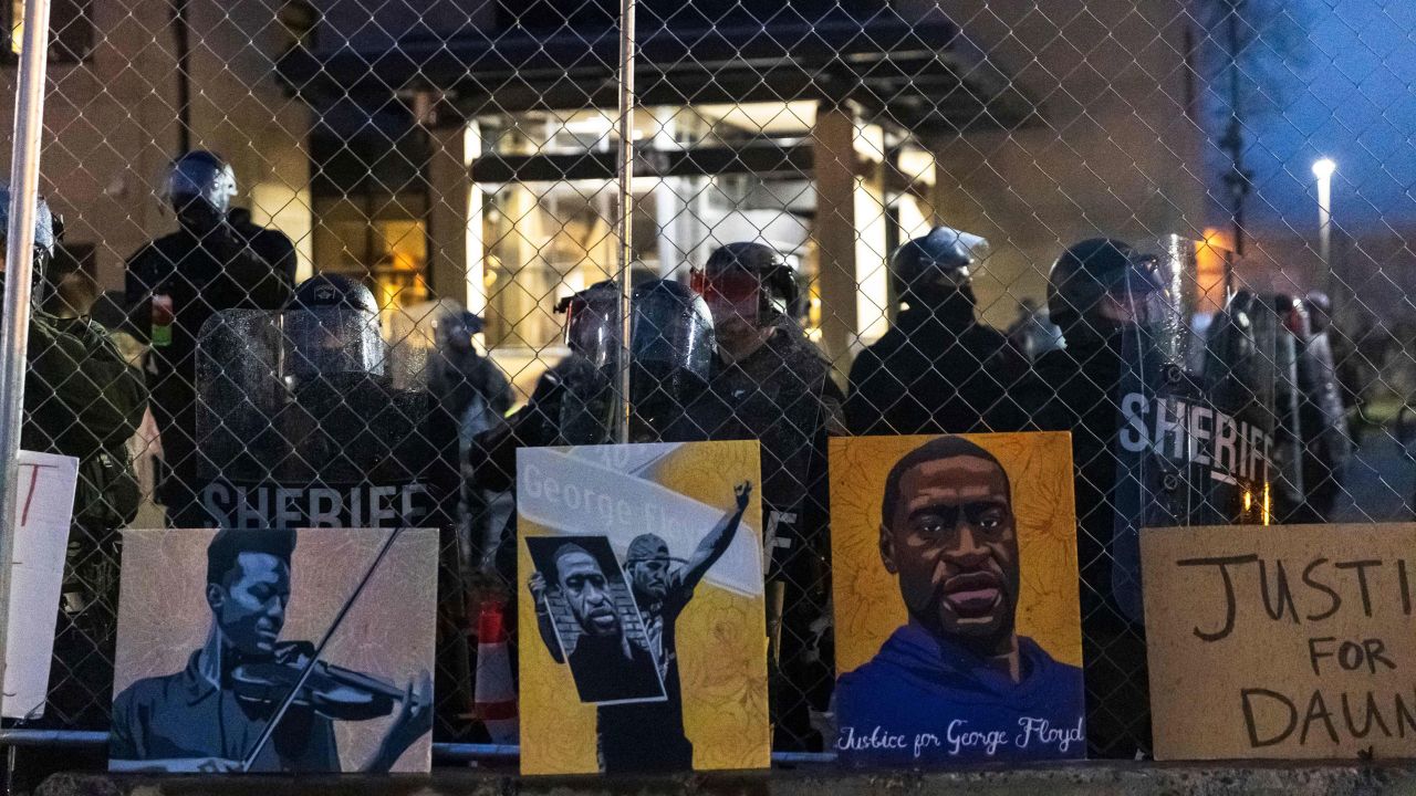 Pictures of Elijah McClain and George Floyd left by demonstrators line the fence outside a Minnesota police station in April 2021.