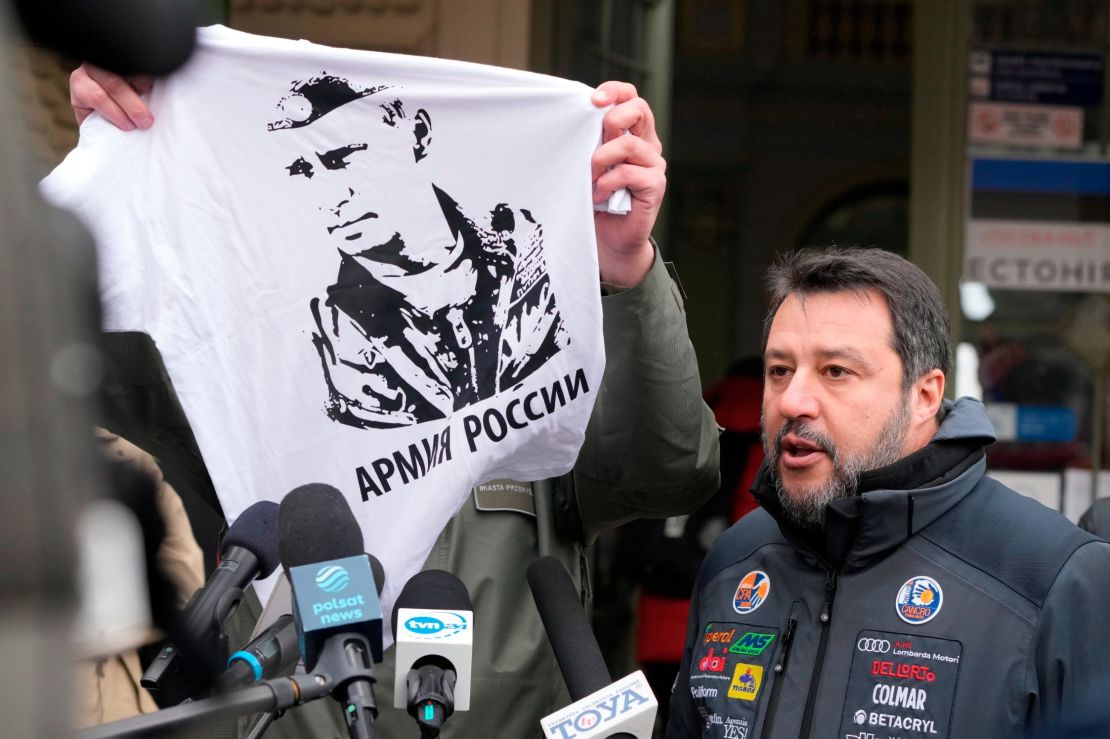 The mayor of Przemysl holds up a T-shirt with the likeness of Vladimir Putin as Matteo Salvini speaks with journalists on March 8, 2022. 