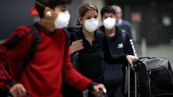 DULLES, VIRGINIA - MARCH 13: Passengers wearing masks arrive at Dulles International Airport March 13, 2020 in Dulles, Virginia. U.S. President Donald Trump announced restrictions on travel from Europe two days ago due to an outbreak of coronavirus (COVID-19). Today is the last day of unrestricted travel from Europe into the United States.  (Photo by Win McNamee/Getty Images)