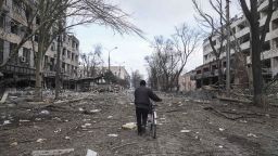 A man walks with a bicycle in a street damaged by shelling in Mariupol, Ukraine, Thursday, March 10, 2022. (AP Photo/Evgeniy Maloletka)