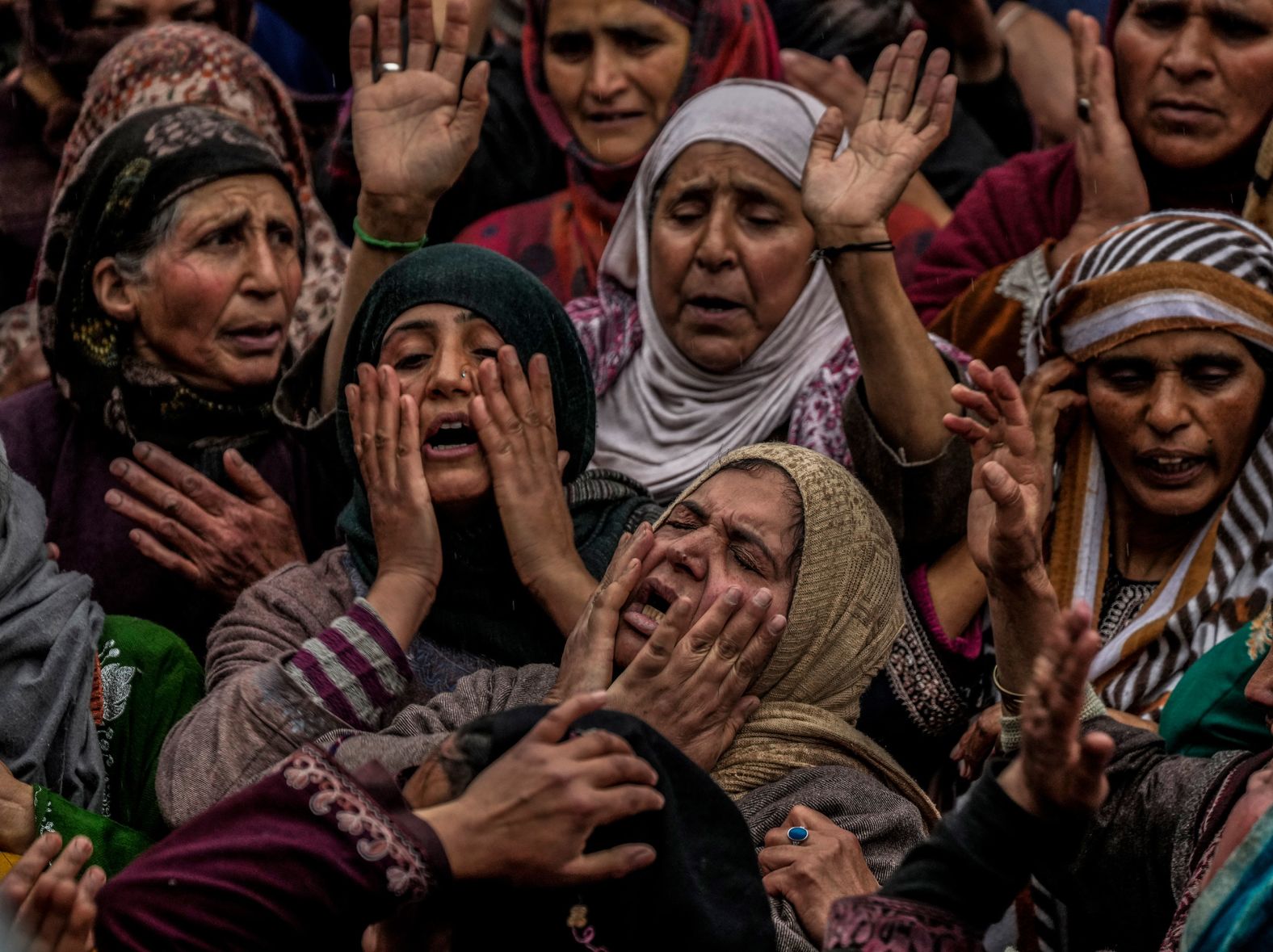 People mourn near the body of Rafia Nazir, a young Kashmiri woman, during her funeral in Srinagar, India, on Monday, March 7. She was killed in a grenade attack at a busy market.