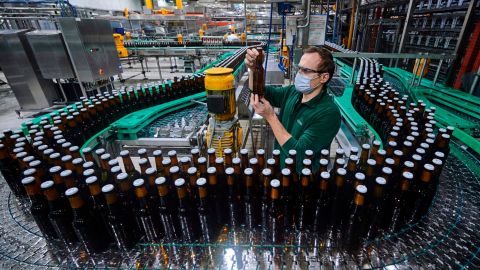 An employee inspects a bottle at a brewery bottling plant in the German state of North Rhine-Westphalia.
