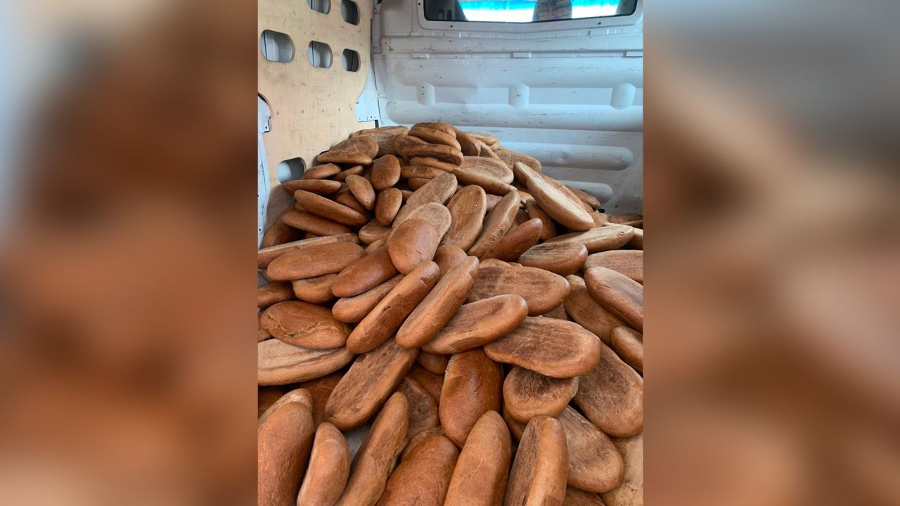 Servetnyk piles bread into the back of a truck to deliver it.