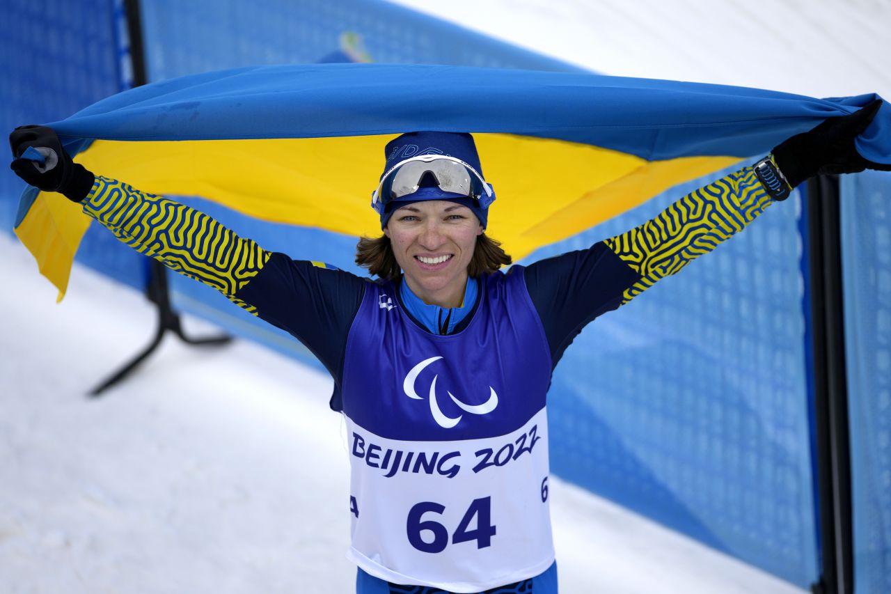 Ukraine's Liudmyla Liashenko celebrates with her national flag after winning gold in a biathlon event on March 11.
