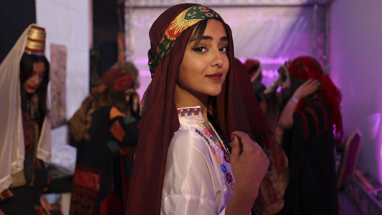 A Palestinian woman, wearing a traditional embroidered dress, poses for a picture during  an event celebrating the registration of Palestinian embroidery on the UNESCO Cultural Heritage List, in the West Bank city of Ramallah on March 9.
