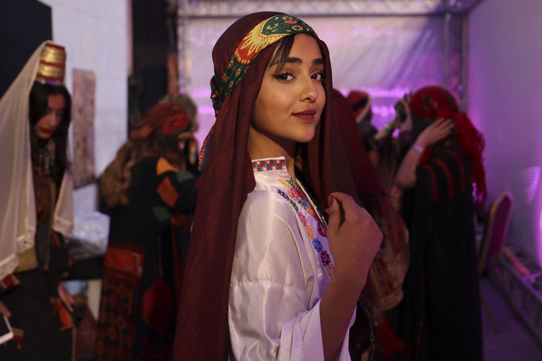 A Palestinian woman, wearing a traditional embroidered dress, poses for a picture during  an event celebrating the registration of Palestinian embroidery on the UNESCO Cultural Heritage List, in the West Bank city of Ramallah on March 9.