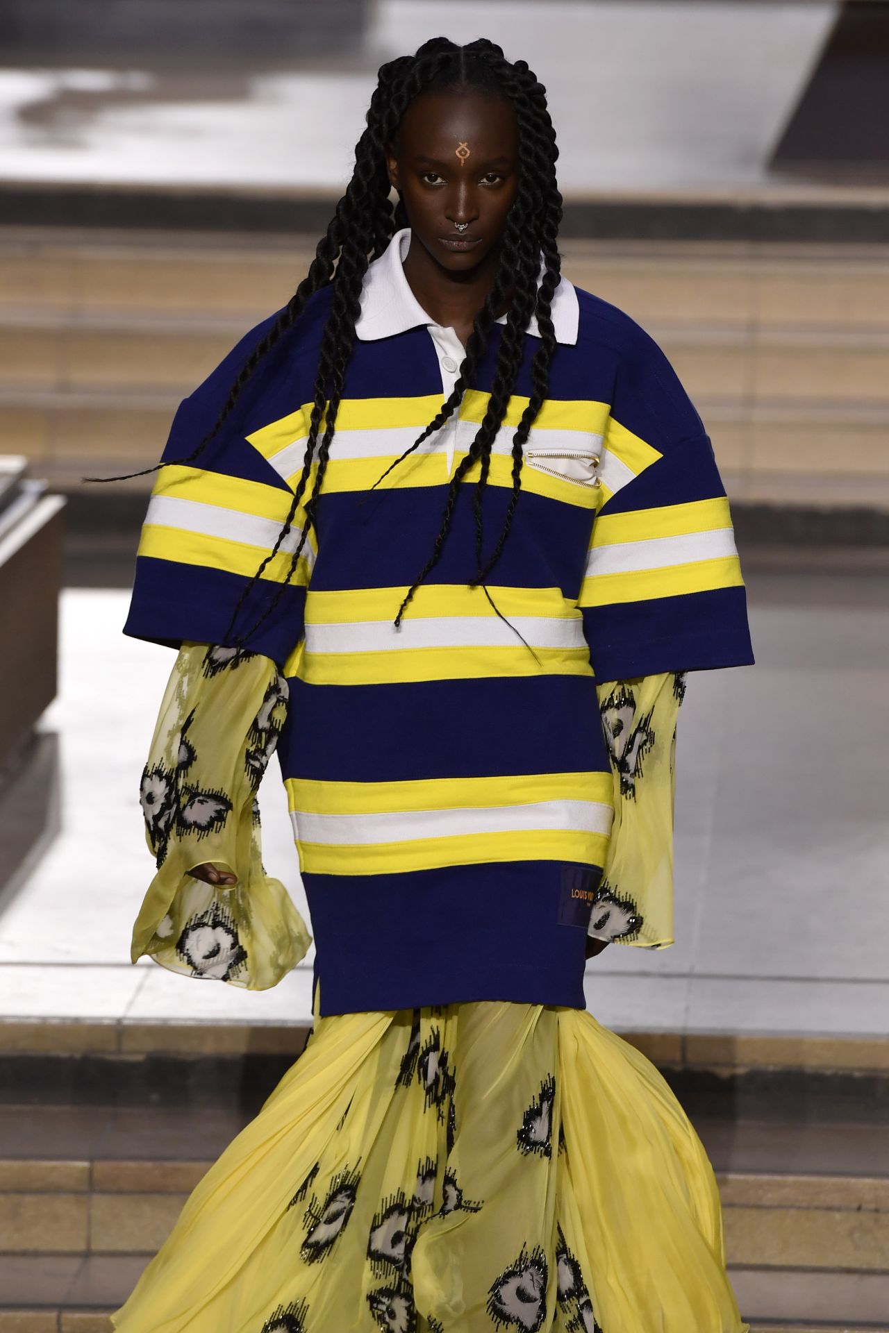 A model walks the runway dressed in yellow and blue during the Louis Vuitton Fall-Winter 2022 show. 