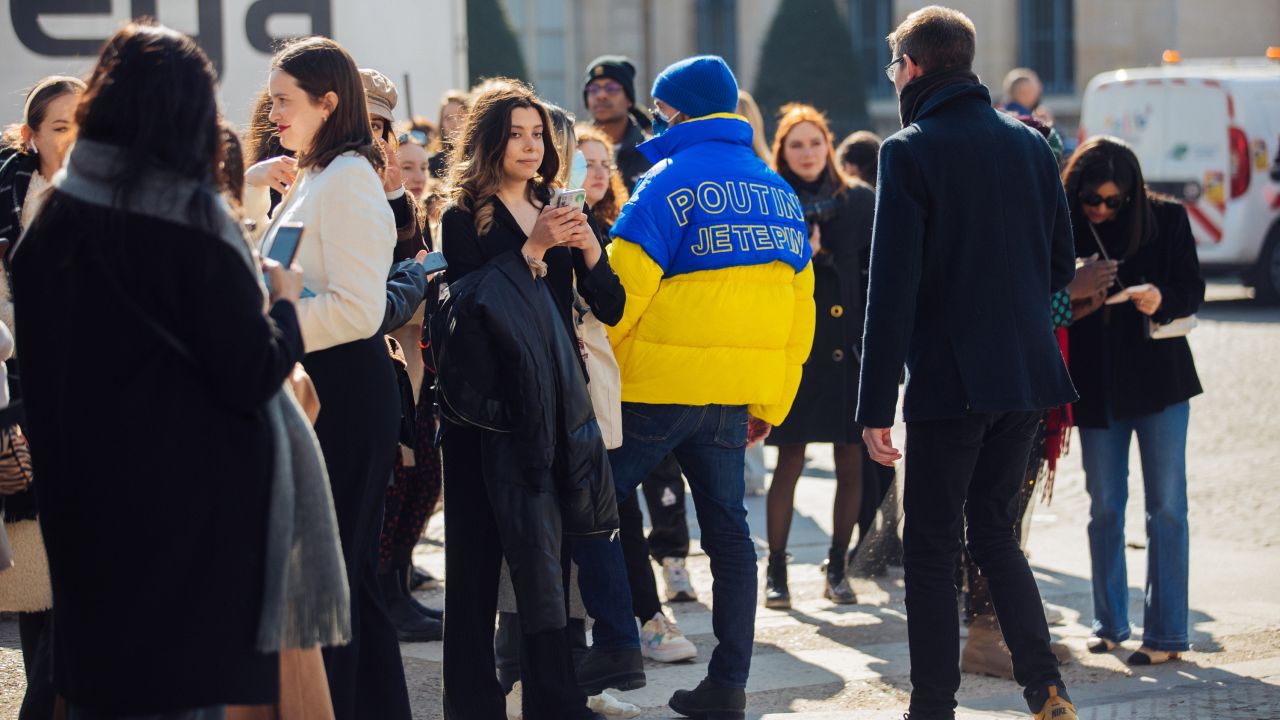 A guest wears a blue and yellow "Poutine Je Te Pine" puffer jacket in solidarity with Ukraine at the Chanel show at the Grand Palais Éphémère during Paris Fashion Week Fall/Winter 2022 on March 08, 2022 in Paris, France. 