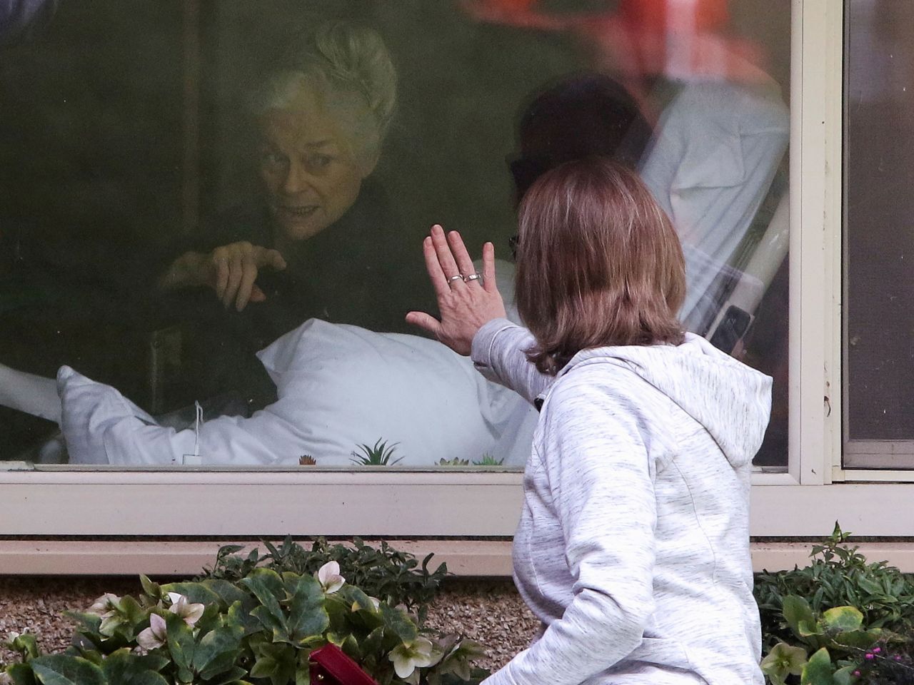 Lori Spencer visits her mother, 81-year-old Judie Shape, at the Life Care Center, a nursing home in Kirkland, Washington, in March 2020. The facility became an early epicenter of the pandemic in the US, and Shape was among those who tested positive. She has since recovered.