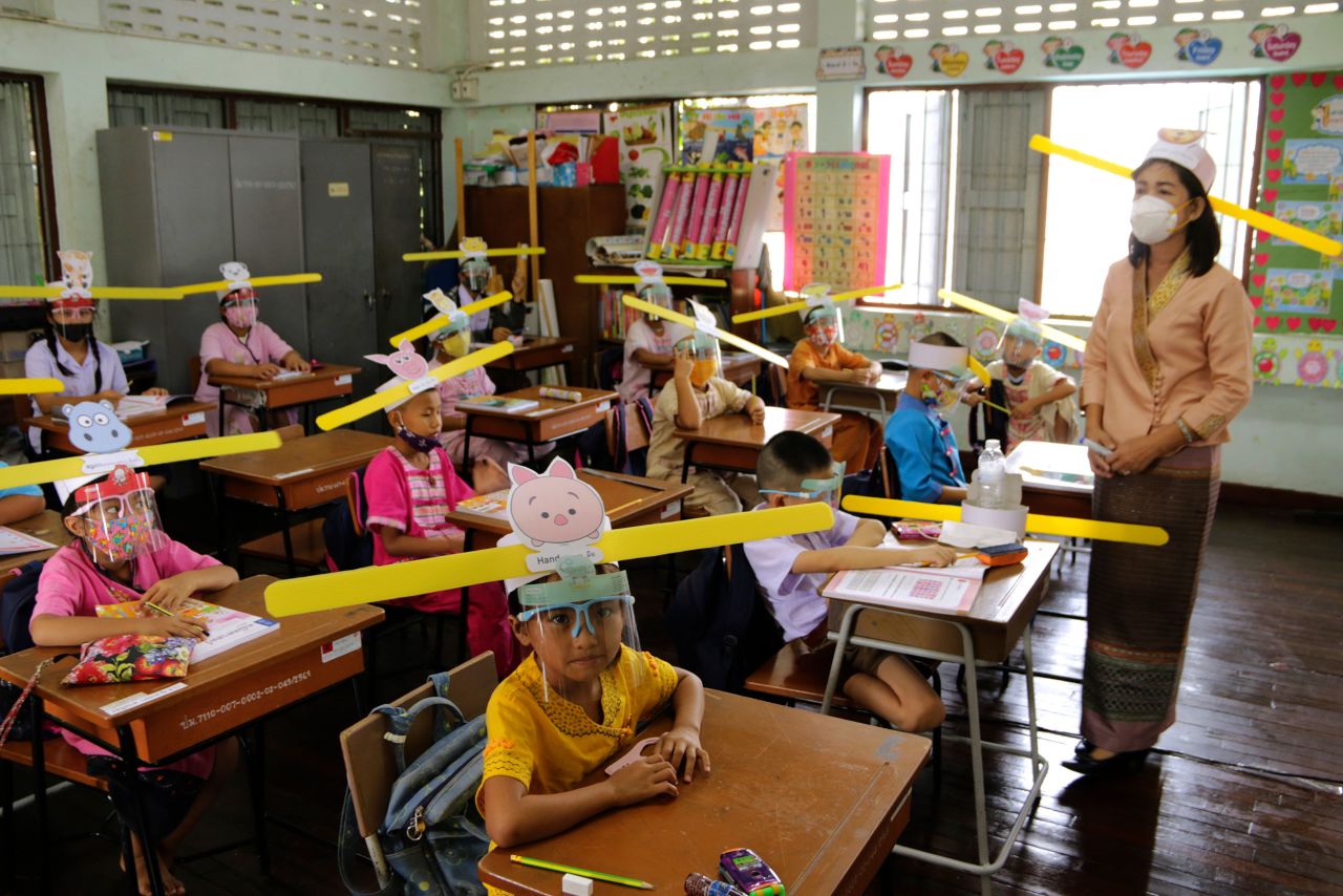Students and their teacher wear hats to help them practice social distancing at a school in Chiang Mai, Thailand, in July 2020. Many children were anxious to return to classes after so many months away, even if they had to observe new Covid-19 mitigation measures.