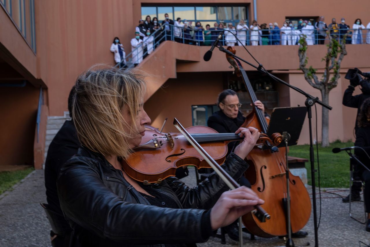 Medical workers in Athens, Greece, watch as the Hellenic Broadcasting Corporation orchestra performs in the yard of the Attikon University Hospital in April 2020.