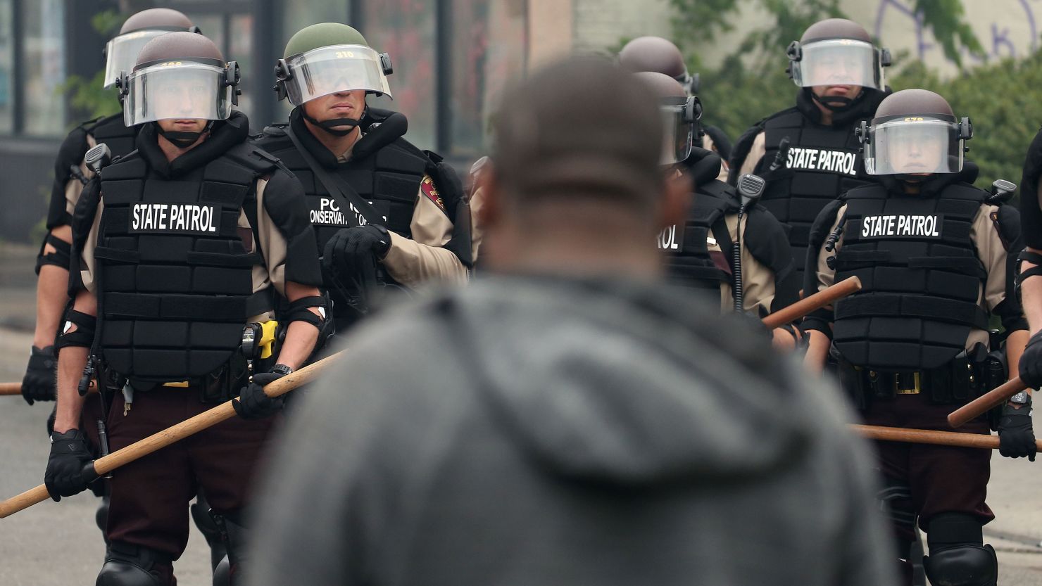 A man stands in front of police as they hold a line during protests on May 29, 2020 in Minneapolis, Minnesota.