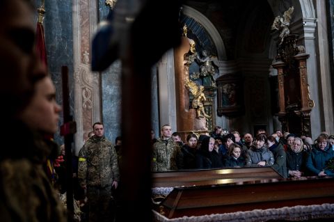 People pay their respects during a funeral service for three Ukrainian soldiers in Lviv on March 11. Senior Soldier Andrii Stefanyshyn, 39; Senior Lt. Taras Didukh, 25; and Sgt. Dmytro Kabakov, 58, were laid to rest at the Saints Peter and Paul Garrison Church. Even in this sacred space, the sounds of war intruded: an air raid siren audible under the sound of prayer and weeping. Yet no one stirred. Residents are now inured to the near-daily warnings of an air attack.