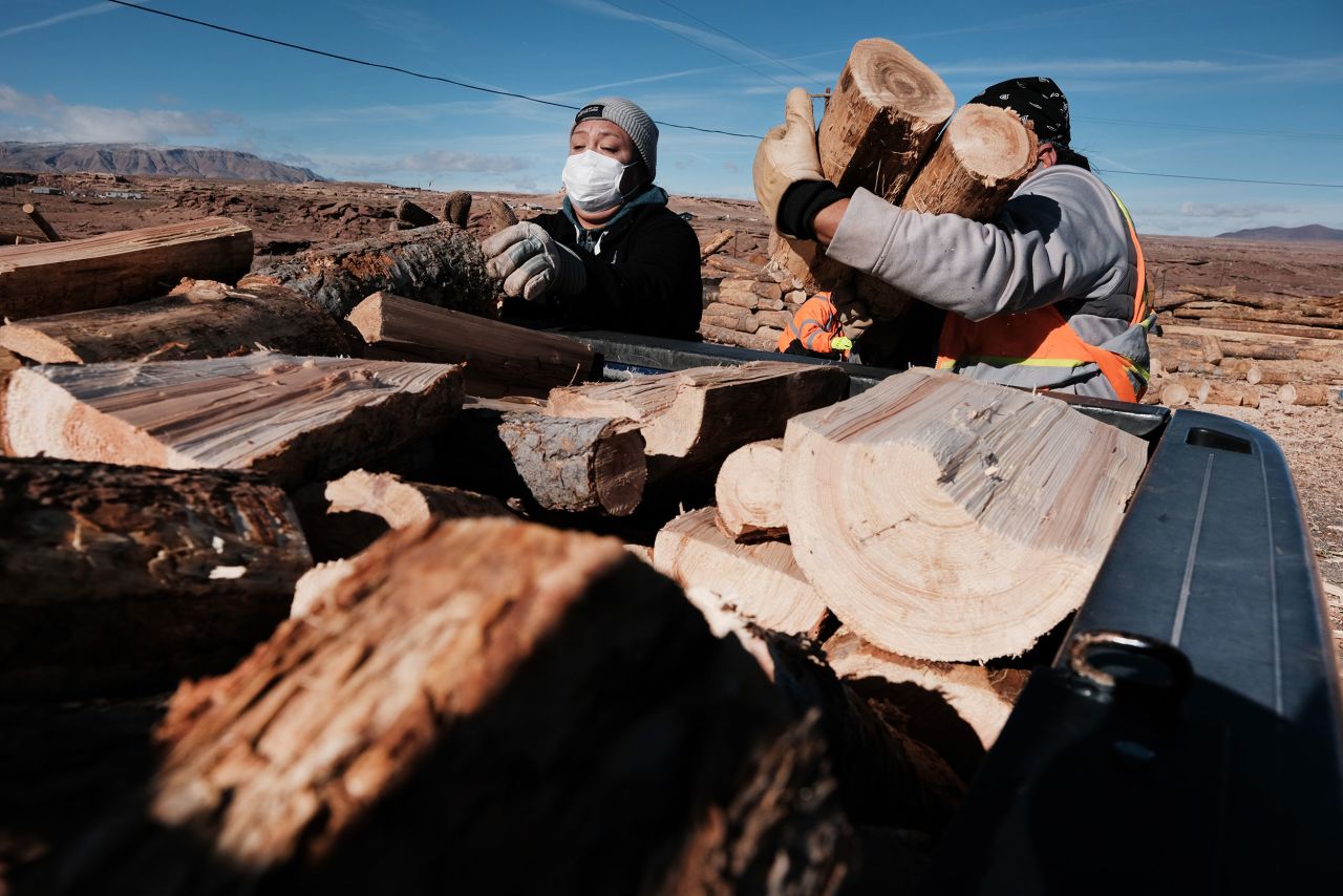 Members of the Navajo community place cut wood used for cooking and heating into a truck on a reservation in December 2021 in Arizona. The wood, thinned from unhealthy forests in the area, was accessed through a partnership with the National Forest Foundation and their 'Wood for Life' initiative.