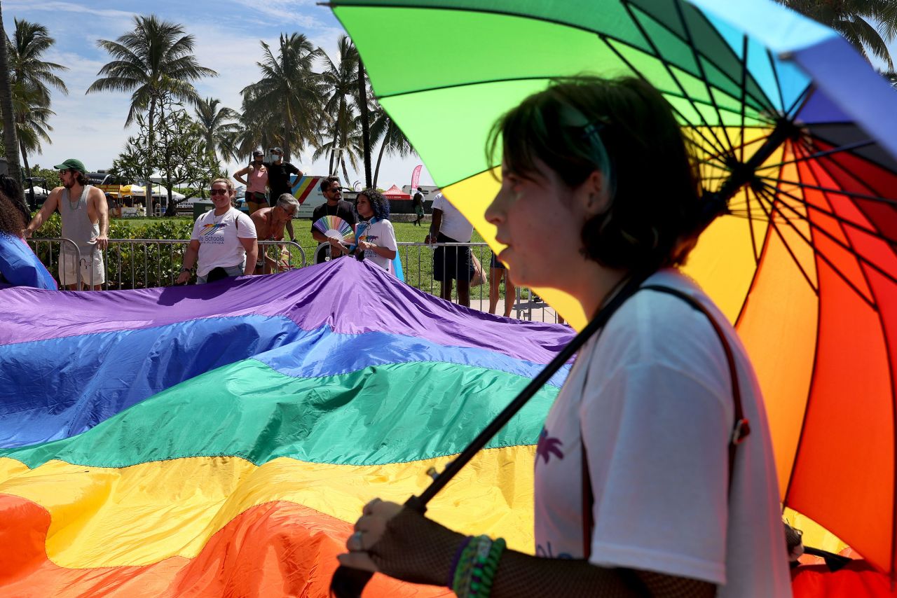 People carry rainbow flags while they march in the Miami Beach Pride Parade along Ocean Drive in September 2021. The annual Florida event was canceled in 2020 and postponed for months last year due to Covid-19. 