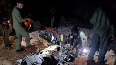 People work around what Pakistani security sources say is the remains of a missile fired into Pakistan from India, near Mian Channu, Pakistan, March 9, 2022. 