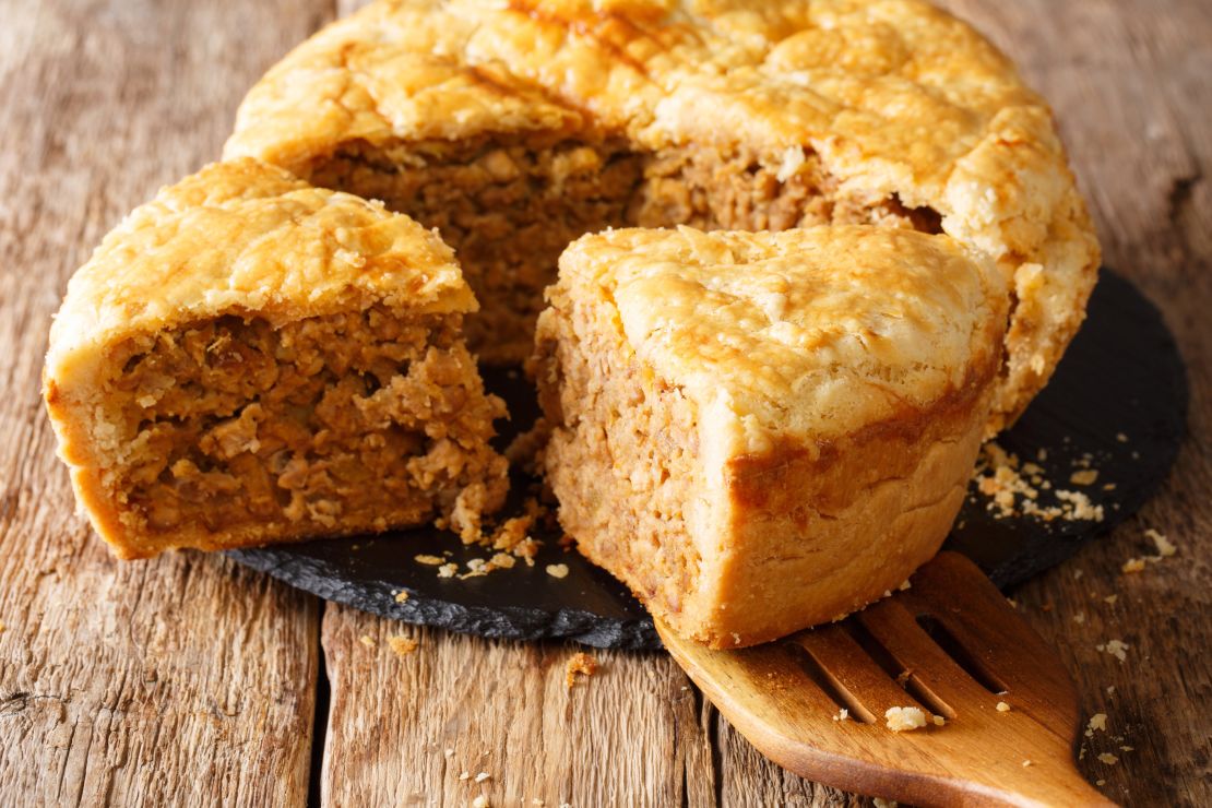 Sliced tourtiere pie with meat, mashed potatoes and spices close-up. horizontal