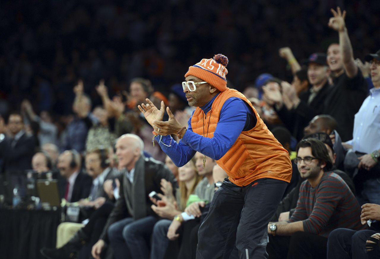 Lee cheers on his beloved New York Knicks during an NBA game in 2014. Lee's Knicks fandom is well documented, and he's frequently seen sitting courtside.