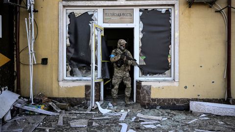 A Ukrainian serviceman exits a damaged building after shelling in Kyiv, on March 12, 2022. 