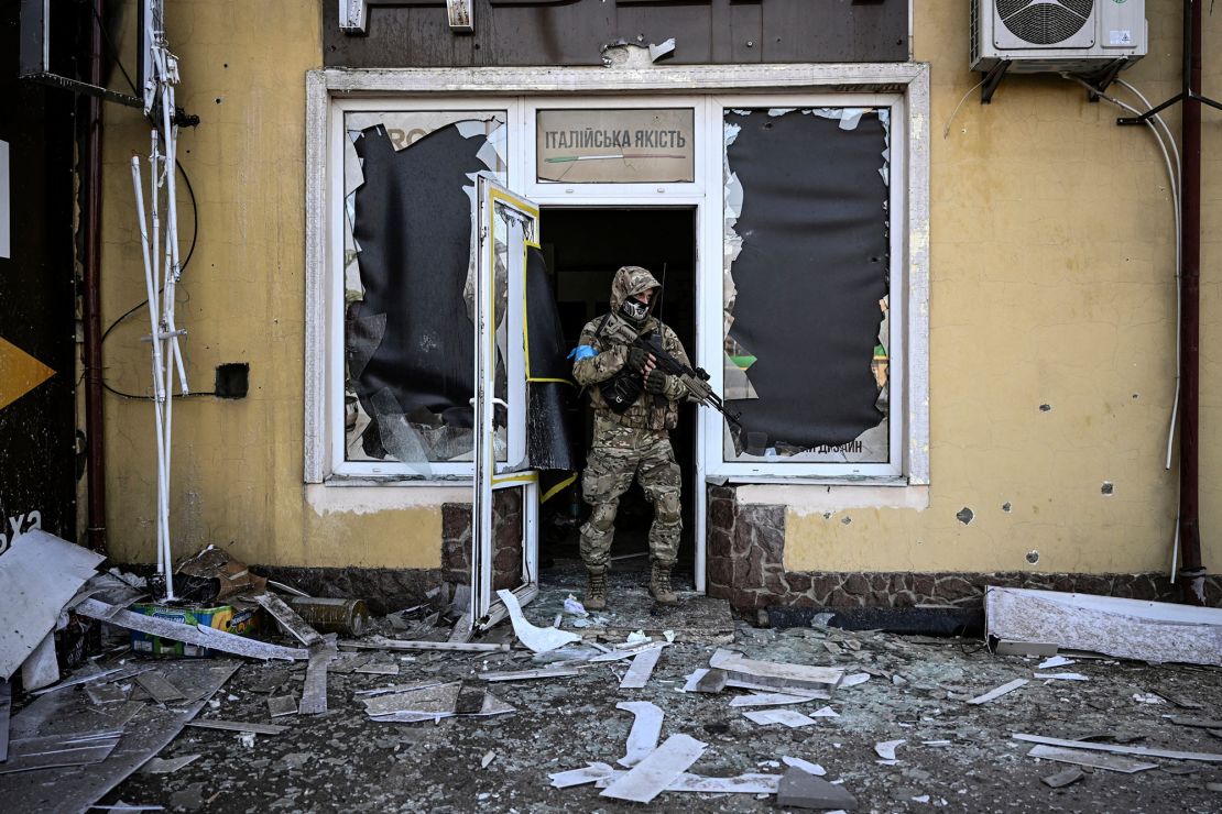 A Ukrainian serviceman exits a damaged building after shelling in Kyiv, on March 12, 2022. 