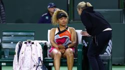 Naomi Osaka of Japan speaks with WTA supervisor Clare Wood after play was disrupted by a shout from the crowd during her straight sets defeat against Veronika Kudermetova of Russia in their second round match on Day 6 of the BNP Paribas Open at the Indian Wells Tennis Garden on March 12, 2022 in Indian Wells, California.