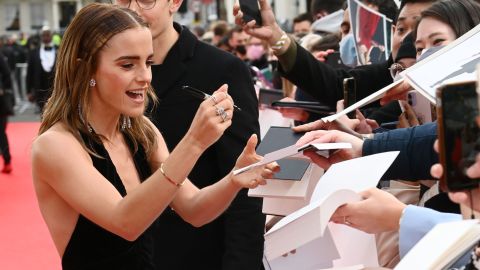 Actress Emma Watson signs autographs for fans.