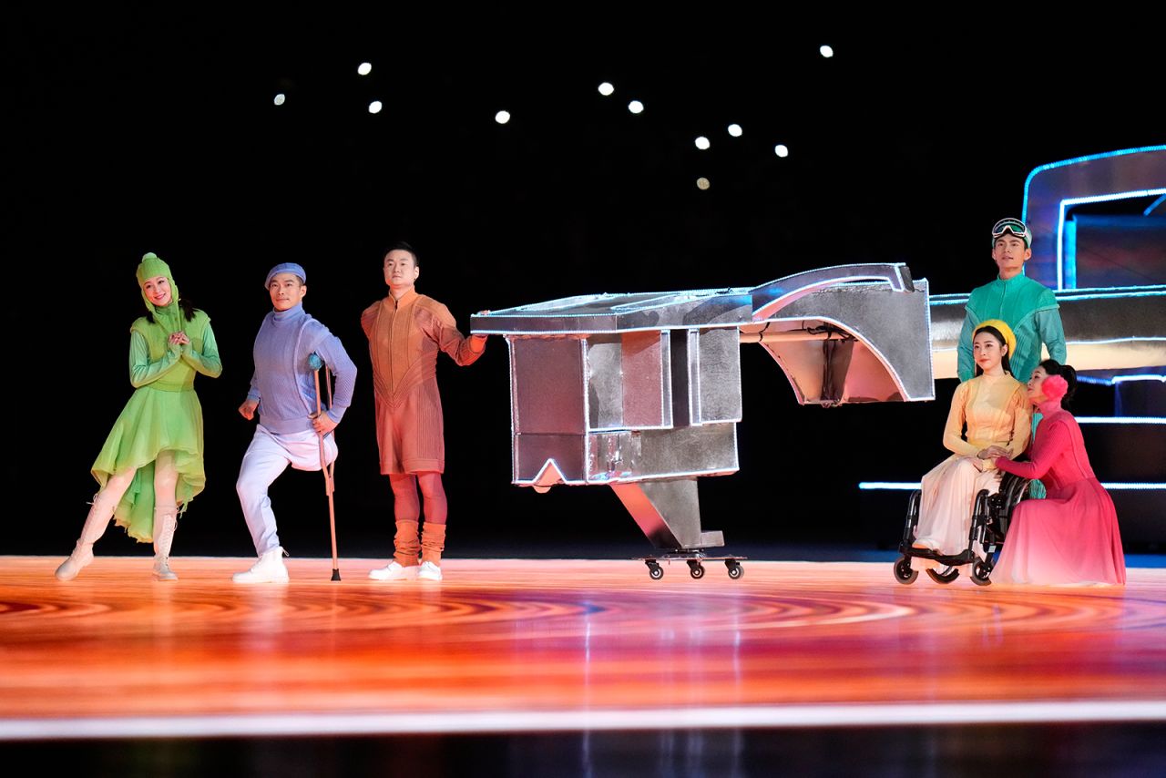 Performers place a needle on a giant record player during the closing ceremony.