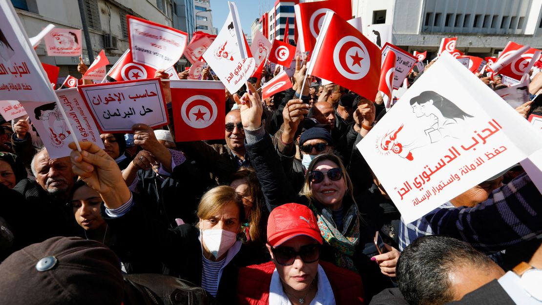 Demonstrators hold placards and Tunisian national flags during a protest Sunday in Tunis against President Kais Saied's seizure of governing powers.