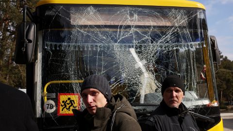 Yuri (R), a bus driver, and his son Ruslan, a doctor, stand in front of a bus damaged in air strikes at the Yavoriv military complex on March 13. 
