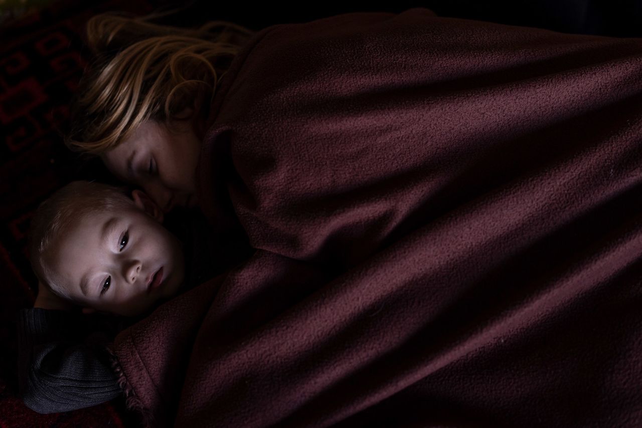 A mother and son rest in Lviv, Ukraine, while waiting to board a train to Poland on March 12.