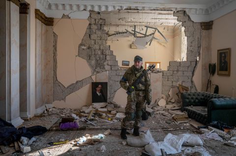 A Ukrainian soldier surveys a destroyed government building in Kharkiv on March 13.