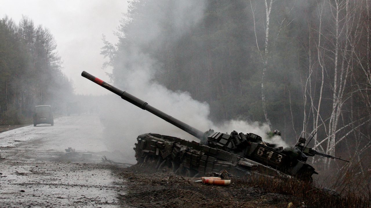 Smoke rises from a Russian tank destroyed by the Ukrainian forces on the side of a road in Lugansk region on February 26, 2022. 