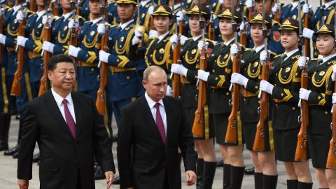 Russian President Vladimir Putin (C) reviews a military honour guard with Chinese leader Xi Jinping (L) in Beijing on June 8, 2018. 