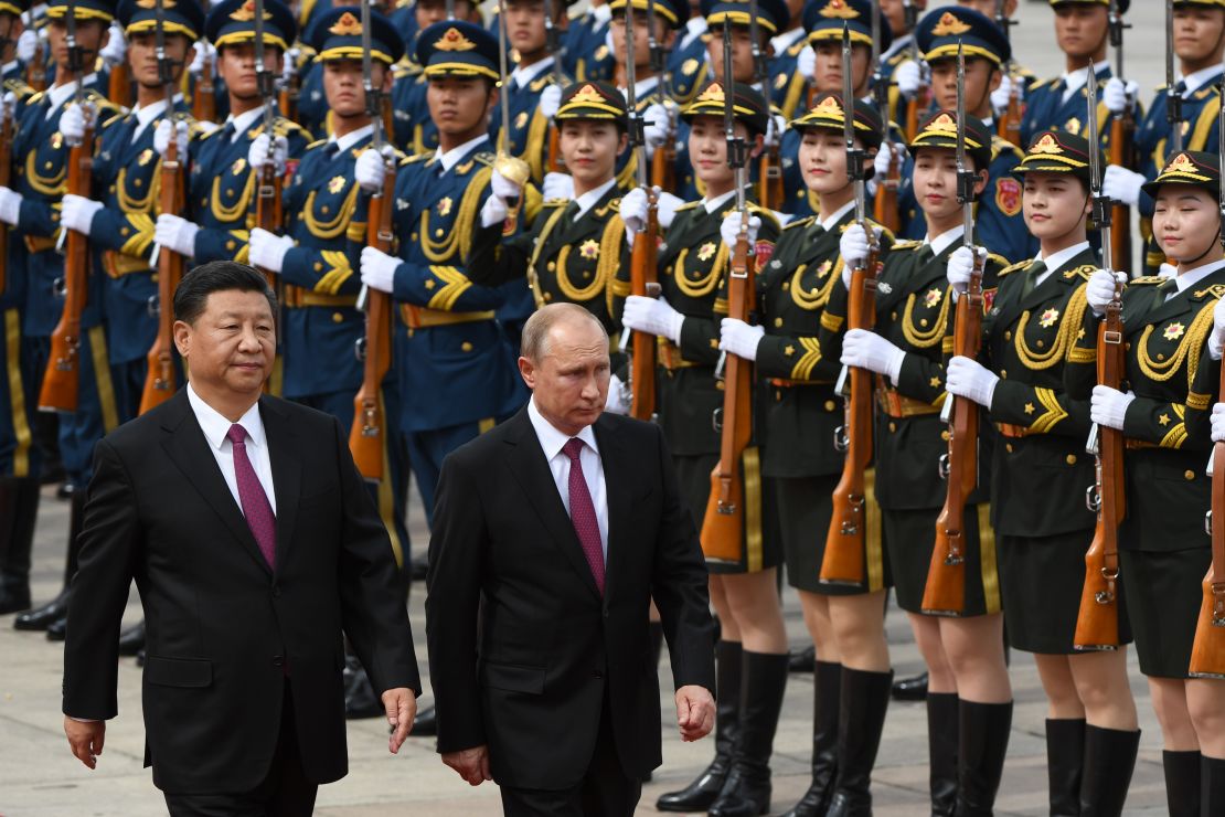 Russian President Vladimir Putin (C) reviews a military honour guard with Chinese leader Xi Jinping (L) in Beijing on June 8, 2018. 