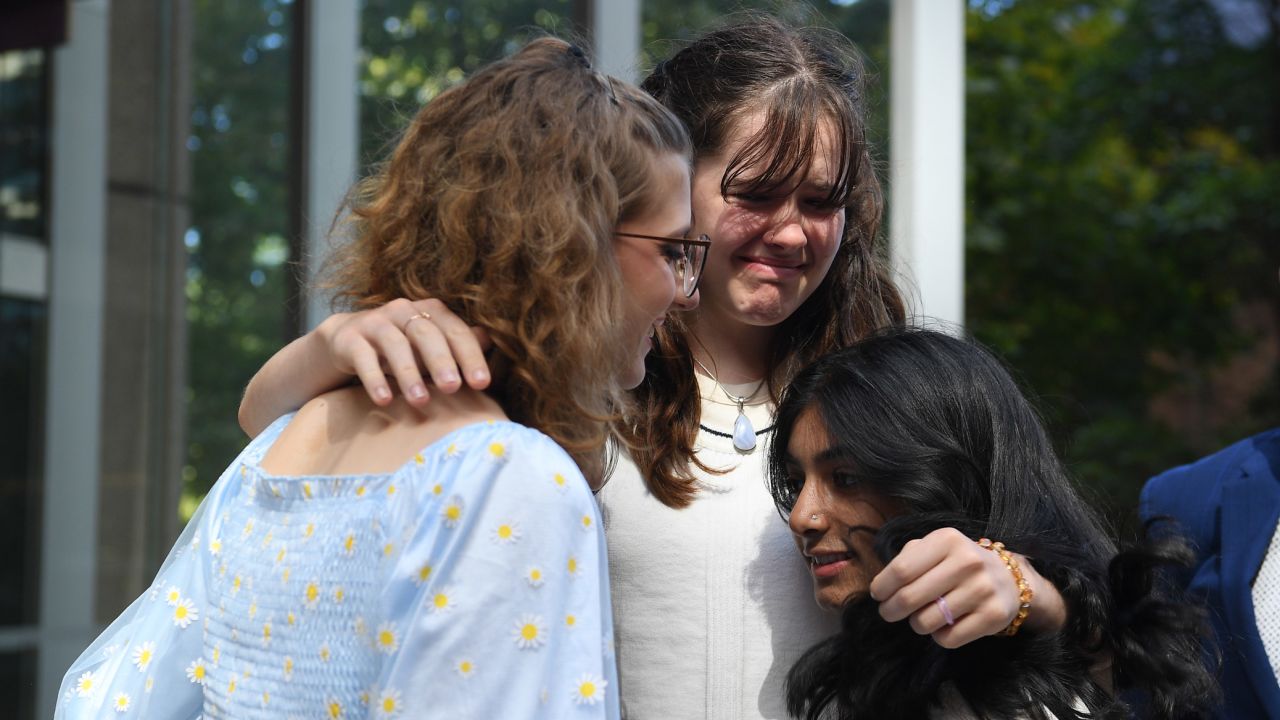 Ava Princi, 18, Luca Saunders, 16, and Anjali Sharma, 17, console each other after Tuesday's ruling.   