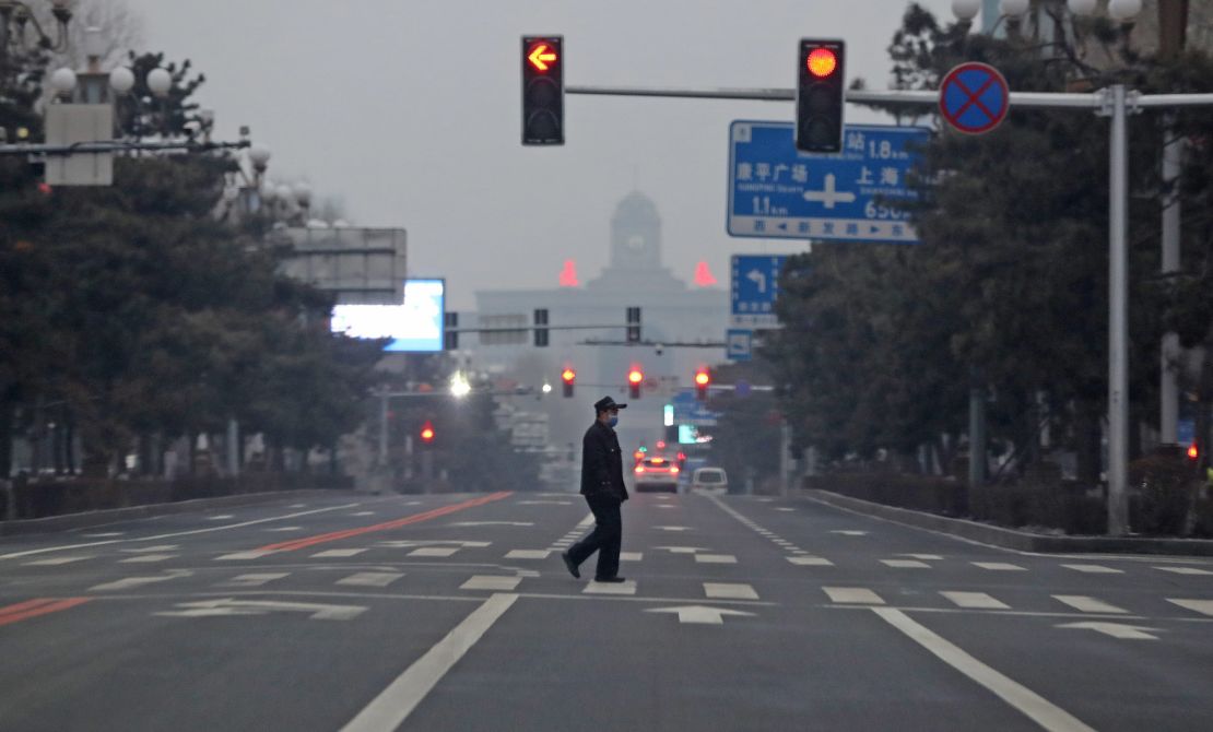 A man walks across an empty road in Changchun, China, on March 14.