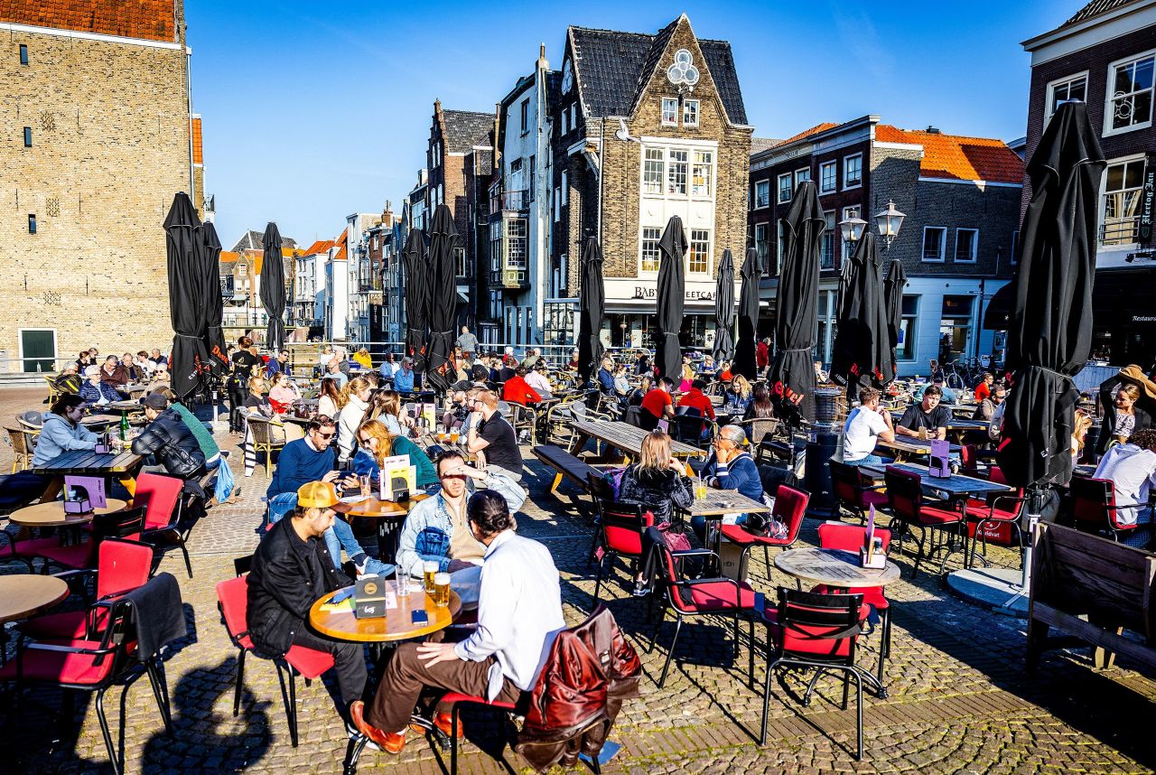 People sit outside on a sunny afternoon in Dordrecht, Netherlands, on March 10, 2022.
