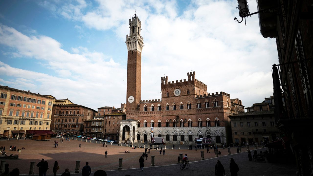 People walk in Piazza del Campo near the Palazzo Comunale on March 4, 2022, in Siena, Italy.